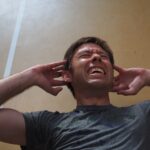 man plugging ears